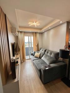 a living room with a couch and a television at Lindo apartamento no centro de Canoas in Canoas