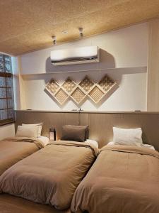台南錦小路平屋包棟民宿 Nishikikoji inn Bungalow BnB -寵物友善-國旅卡-T aiwan Lucky Land vouchers -Nintendo Switch- NETFLIX- 一軒家貸切的卧室配有两张床,墙上有灯