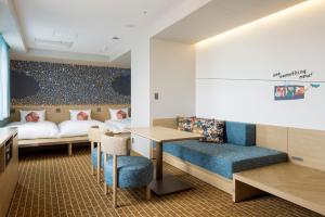 a room with a bed and a table and chairs at OMO5 Hakodate by Hoshino Resorts in Hakodate