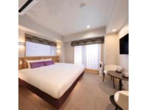 een slaapkamer met een groot wit bed en een bureau bij Gion Crystal Hotel - Vacation STAY 21877v in Kyoto