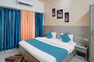 a bedroom with a large bed with blue sheets at Hotel Aradhana palace in Rishīkesh