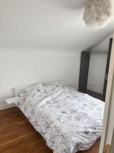 a bedroom with a bed with a white comforter at Maison de ville in Montceau-les-Mines