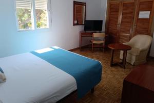 a bedroom with a bed and a desk and a chair at Hotel Santa María in Palos de la Frontera