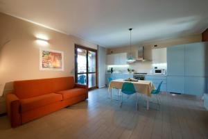 ペスキエーラ・デル・ガルダにあるCasa vacanze da riki appartamento 3のオレンジ色のソファとテーブルのあるリビングルーム