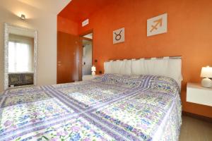 ペスキエーラ・デル・ガルダにあるCasa vacanze da riki appartamento 3のベッドルーム1室(オレンジ色の壁の大型ベッド1台付) +15枚の写真