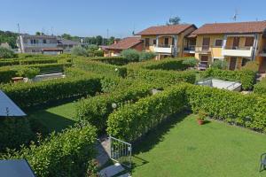 ペスキエーラ・デル・ガルダにあるCasa vacanze da riki appartamento 3の緑の茂みと建物を背景にした庭園