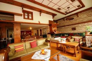 uma sala de estar com sofás e mesas e uma parede de tijolos em Hotel Elvetia em Karpenision