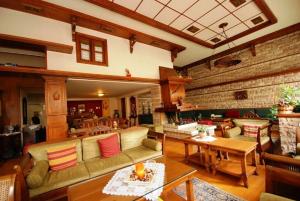 a living room with couches and tables and a brick wall at Hotel Elvetia in Karpenisi