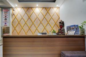 a counter in a restaurant with a wall with a gold at Hotel Aradhana palace in Rishīkesh