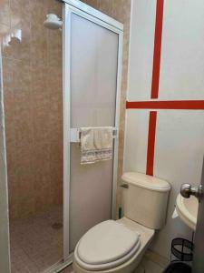 ein Badezimmer mit weißer Toilette und Dusche in der Unterkunft Acogedor depaetamento por estadio Dorados in Casas