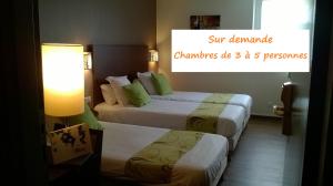 a hotel room with two beds and a sign that reads sun demand diamonds die at Le Pavillon de Rouen in Franqueville-Saint-Pierre