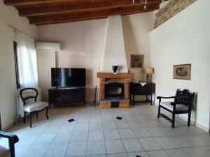 a living room with a fireplace and a flat screen tv at Mastiha house in Neochórion