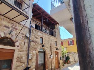 an old stone building with a balcony on top of it at Mastiha house in Neochórion