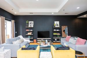 a living room with two couches and a tv at Grand Loft ON THEE Broadway Strip in Nashville +13 photos
