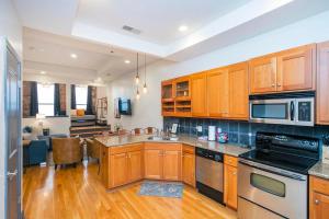a kitchen with wooden cabinets and a living room at Loft Literally on Broadway Live Music & Bars in Nashville
