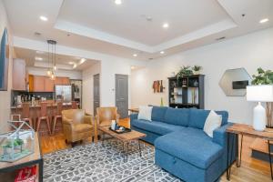 a living room with a blue couch and a kitchen at Loft Literally on Broadway Live Music & Bars in Nashville