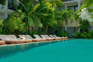 a swimming pool with lounge chairs next to a building at Khmer House Boutique in Siem Reap