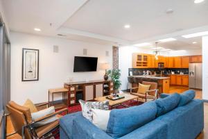 a living room with a blue couch and a kitchen at Spacious Penthouse ON the Broadway Strip in Nashville +14 photos