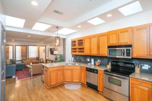 a kitchen with wooden cabinets and a living room at Spacious Penthouse ON the Broadway Strip in Nashville