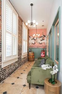 sala de estar con sofá verde y algunas ventanas en 2 Chic Lofts right ON Broadway Strip Sleeps 10, en Nashville 19 fotos más