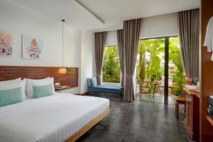a bedroom with a bed and a chair and windows at Khmer House Boutique in Siem Reap