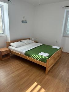a bedroom with a large bed with a green blanket at Beach House Murter in Murter
