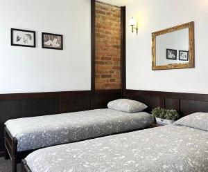 a bedroom with two beds and a mirror on the wall at Pensjonat Gogol.s in Wrocław