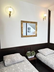 two beds in a room with a mirror at Pensjonat Gogol.s in Wrocław