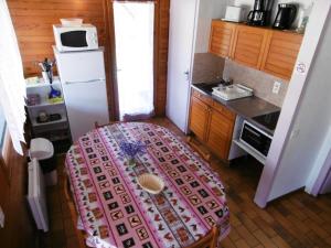 Una pequeña cocina con una mesa y un refrigerador. en La bourdaine, en Brocas 3 fotos más