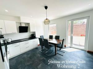 a kitchen with a table and chairs in a kitchen at Bachhaus am Rathaus 2 in Emden