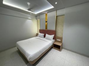 a bedroom with a white bed in a room at Hotel The West Coast in Vasai