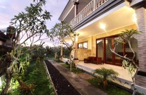 a house with a porch with a bench in the yard at Eka Dwi Guest House in Gianyar