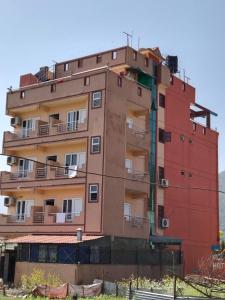 Trisūli BāzārHotel Royal Inn Batar的一座红色的建筑,旁边设有阳台