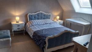 a bedroom with a blue bed and two night stands at La Vie Est Belle in Kortemark