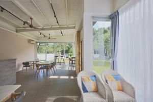 a living room with chairs and a table and a window at OwlStay Green Villa in Pinghe