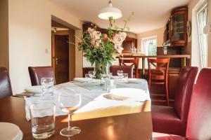 a dining room table with a vase of flowers on it at Laguna Resort in Budzisław