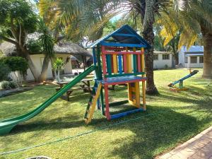 a playground with a colorful play set in a yard at Ombinda Country Lodge in Outjo