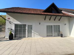 a white house with glass doors and a tile roof at CentralPark Suites in Maribor