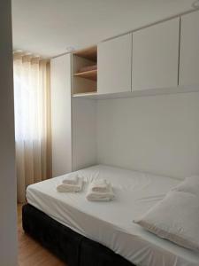 a white bed with two towels on top of it at Casa Além Da Ponte in Vouzela