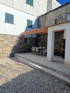 a patio with chairs and a table in a building at Casa Além Da Ponte in Vouzela