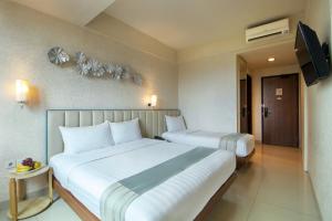 Una cama o camas en una habitación de Solaris Hotel Malang