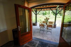 an open door to a patio with a table and chairs at B&B De Groene Gast in Montfort
