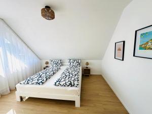 a white room with a bed with pillows on it at Casa del Sol - Ferienwohnung Norddeich in Norddeich