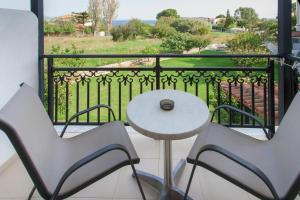 a balcony with a table and two chairs and a view at Vontzos Hotel in Achladies