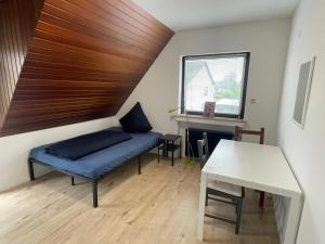 a room with a bed and a table and a window at Gemütliches Gästezimmer im Casa Kirchweg in Gladbach