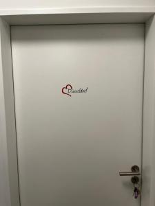 a white door with a sign on it at Gemütliches Gästezimmer im Casa Kirchweg in Gladbach +2 photos