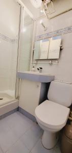 a bathroom with a white toilet and a sink at Urban Haven in Deauville