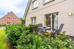a patio with a table and chairs in front of a house at Fewo Butze Fiev in SPO ⇒ Traumurlaub an der Nordsee in Sankt Peter-Ording
