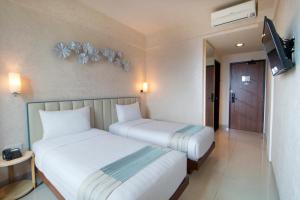Una cama o camas en una habitación de Solaris Hotel Malang