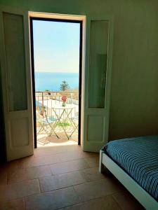a bedroom with an open door with a view of the ocean at Casa Vacanza fronte mare Il Rifugio di Alice in Andrano